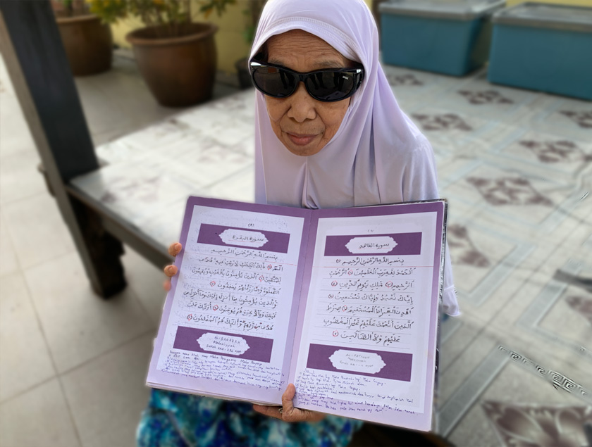 Kalsom Salbiah Mohd Saad, menujukkan senaskah Al-Quran hasil tulisan tangannya. Ia dihasilkan sepanjang beliau menetap di pondok pengajian dewasa itu. - Foto Astro AWANI