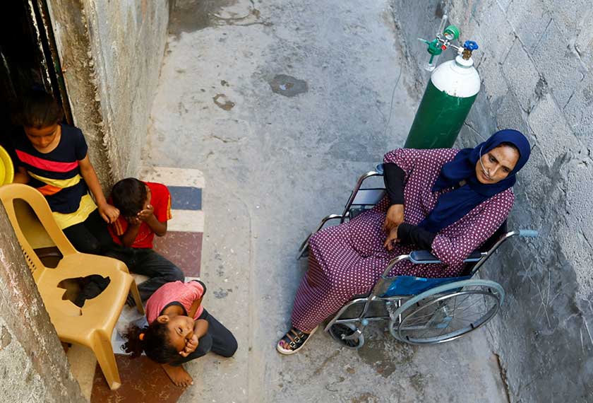 A Palestinian woman, Sabreen Abu Mustafa, struggles for breath outside her house in Khan Younis amid a heatwave in the southern Gaza Strip. - REUTERS