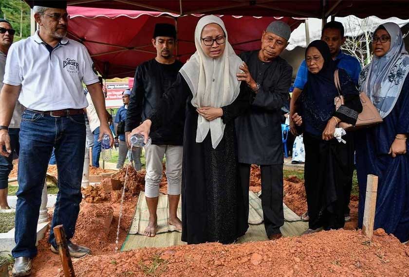 Suzana (tengah) tidak dapat menahan kesedihan ketika menyiram air mawar di pusara suaminya, Mohammad Taufiq selepas selesai urusan pengebumian di Tanah Perkuburan Islam Ukay Perdana hari ini. - Foto Bernama