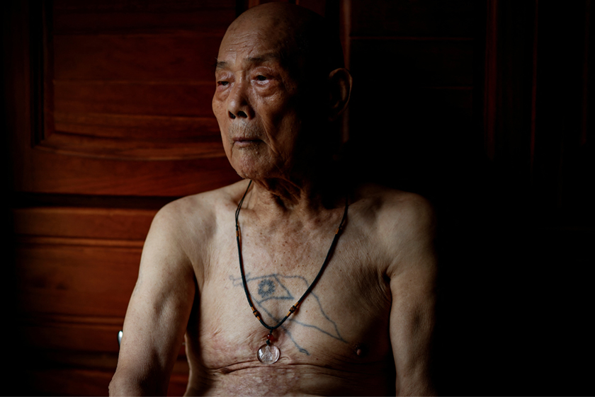 Wang Chih-chuan, 93, poses for a photo, with a Taiwanese flag tattoo on his chest, in his room at Taoyuan Veterans Home in Taoyuan, Taiwan. - REUTERS