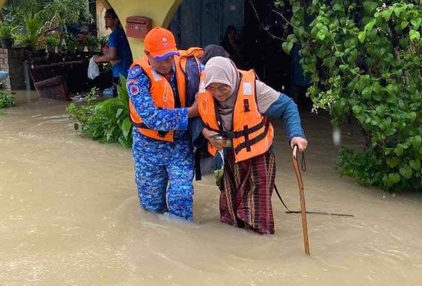 Anggota APM membantu warga emas berpindah di Baroh Pial, Rantau Panjang.