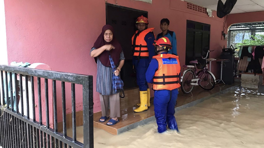Anggota Angkatan Pertahanan Awam (APM) Daerah Bandar Baharu menghulurkan bantuan kepada penduduk yang memerlukan selepas air naik mendadak. - Foto APM