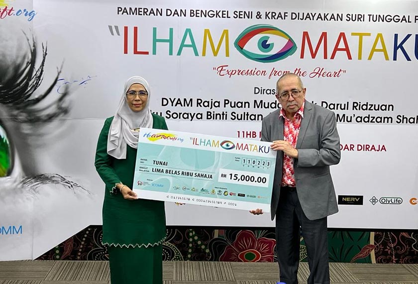 Raja Putra Shah (kanan) menyampaikan replika cek sumbangan dana untuk ibu tunggal sempena program tersebut. - Astro AWANI