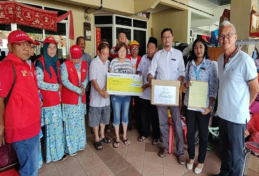 Su Lee (lima dari kiri) menerima sumbangan daripada Perkeso selepas menziarahinya di kediamannya di Taman Mutiara Sabak Bernam di sini pada Selasa, - Foto sinar Harian