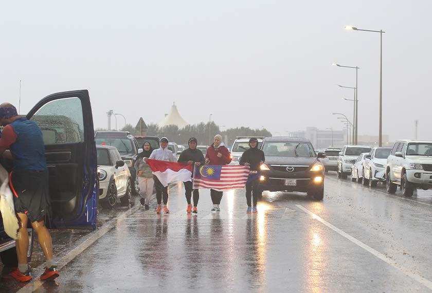 Pasukan Turtle Legs gandingan tiga pelari Malaysia dan seorang pelari Indonesia melepasi garisan penamat dalam hujan lebat  - Gambar  Wan Ahmad Tajuddin/ Malaysian Association of Qatar