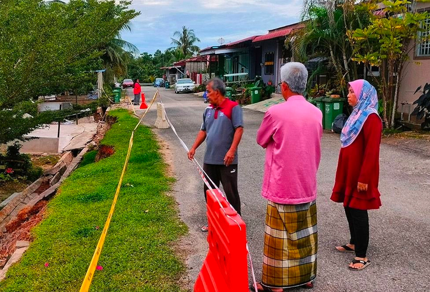 Roslan (kanan) bersama Zainal dan penduduk yang semakin resah dengan kejadian tanah runtuh berhampiran kediaman mereka