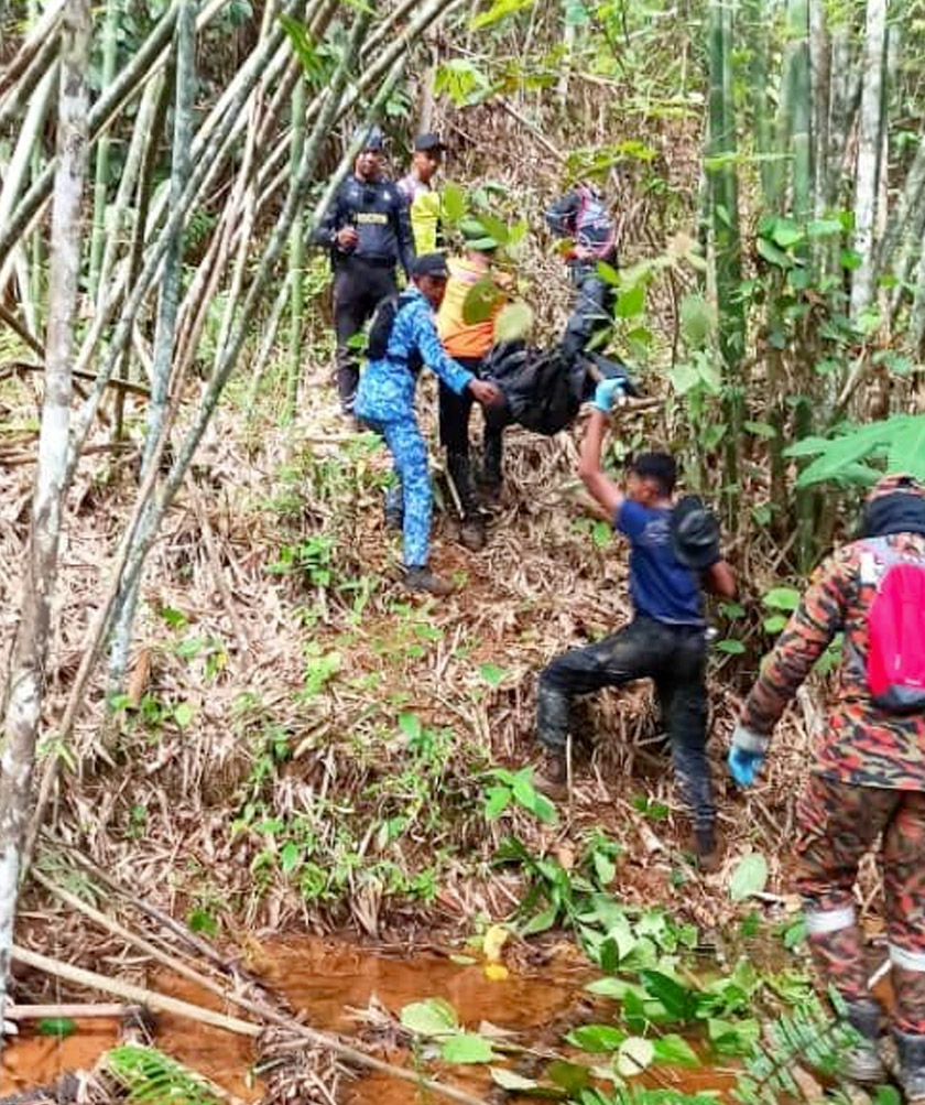 Pasukan SAR membawa mayat Bah Mail Pak Gendet keluar dari hutan untuk proses bedah siasat di Unit Forensik Hospital Lipis.  - Foto PDRM Lipis