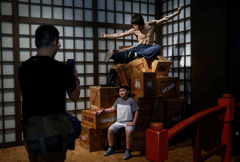 A child poses for photos in front of a wax figure of the martial artist and actor Bruce Lee at the Madame Tussauds Hong Kong, in Hong Kong, China. - REUTERS