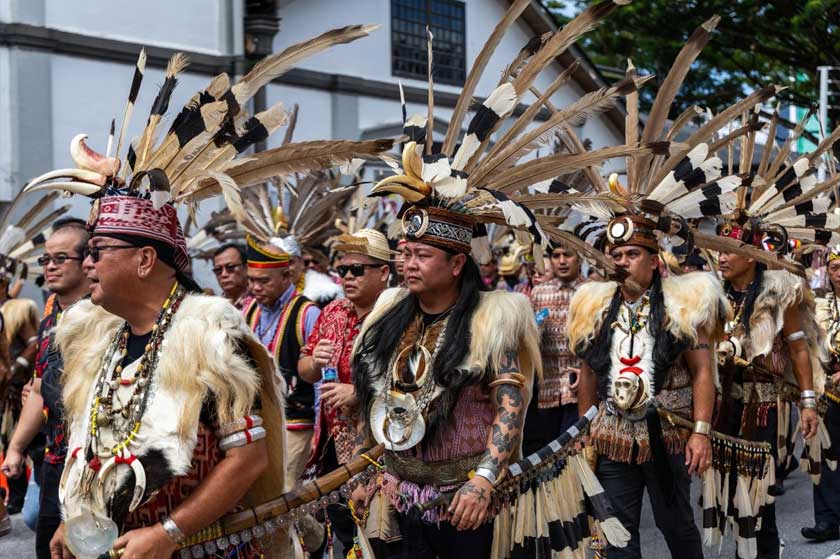 Peserta yang lengkap berpakaian tradisi bersama memeriahkan perarakan Niti Daun di sepanjang Tebingan Kuching. - Astro AWANI