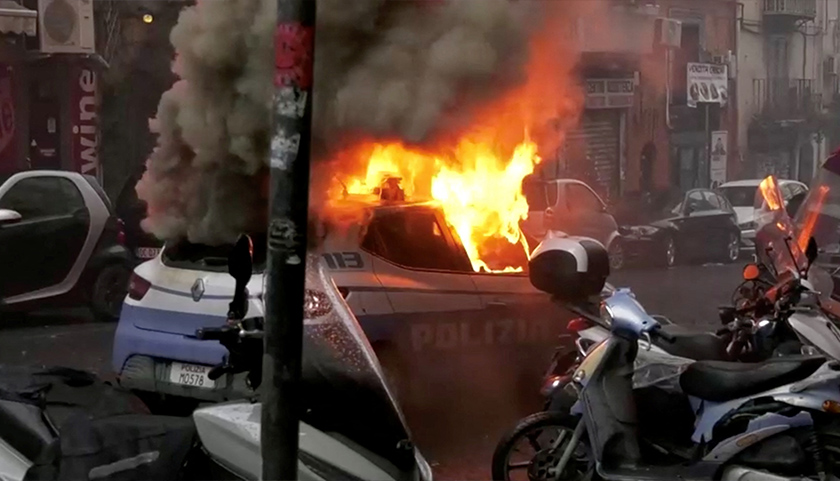 Kereta polis dibakar ketika bertembungan antara penyokong Eintracht Frankfurt dan pasukan polis sebelum perlawanan Liga Juara-Juara UEFA antara Napoli dan Eintracht Frankfurt di Naples. - Foto REUTERS