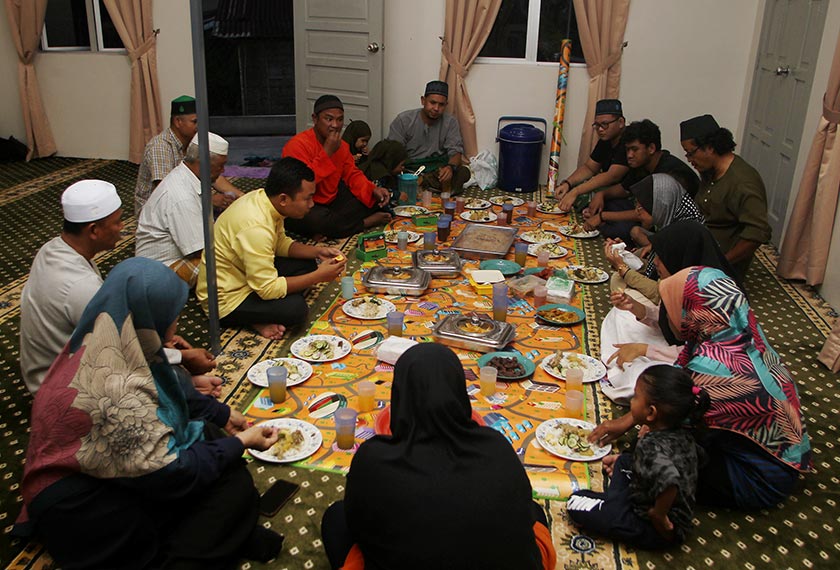 Pelajar Maahad Tahfiz Al-Quran Addin Malim Nawar, Amirul Haziq Faizul, 19, (belakang, kanan) berbuka puasa bersama masyarakat Orang Asli di Surau Al-Hasanah yang baru siap dibina tahun lepas di Kampung Orang Asli Sungai Gapes, Sahom, semalam. - BERNAMA