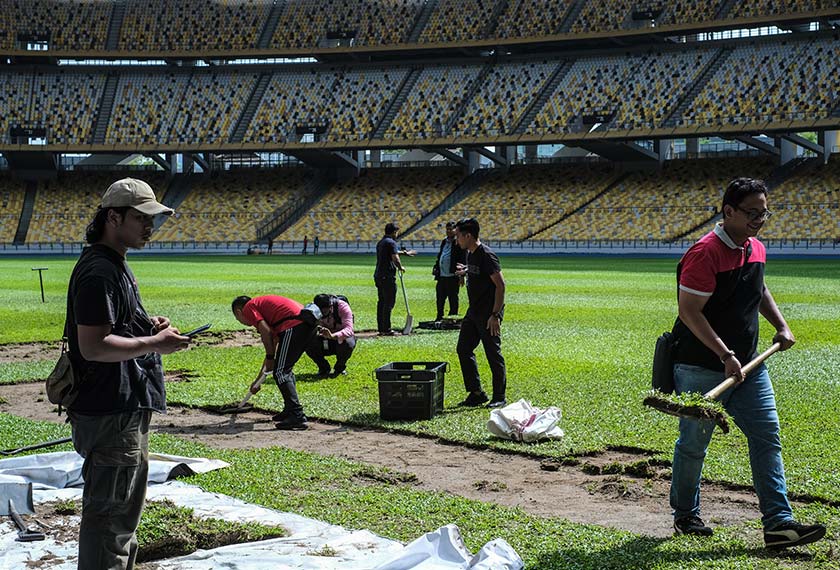 Orang ramai mengambil rumput padang Stadium Nasional Bukit Jalil yang dibuka kepada pengunjung sehingga petang ini sebelum kerja-kerja memasang rumput baharu jenis Zeon Zoysia bagi menggantikan rumput Cow Grass di padang tersebut. - Foto BERNAMA