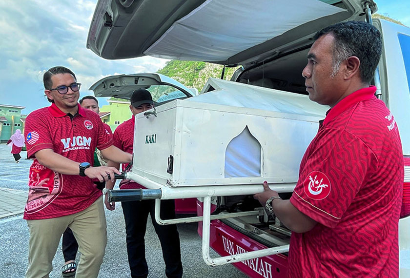 Pengerusi Persatuan Van Jenazah Gua Musang (VJGM) Mohd Azmawi Fikri Abdul Ghani (kiri) menunjukkan pengusung jenazah yang dimuatkan ke dalam setiap kenderaan pelbagai guna (MPV) jenis Toyota Alphard, Naza Ria dan Kia untuk membawa jenazah sewaktu proses penghantaran dilakukan. - Foto BERNAMA