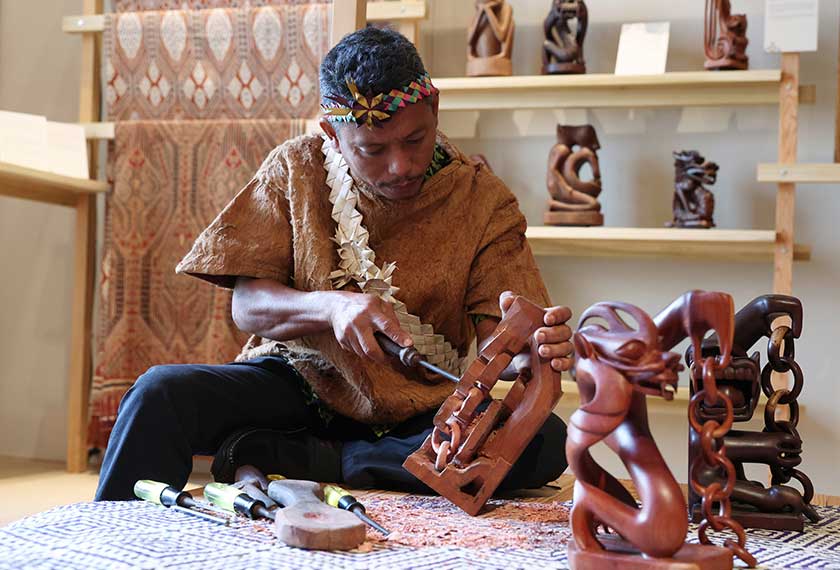 Samri Abdul Rahman mempamerkan kemahirannya mengukir patung ketika ditemui Bernama di Pavilion Antarabangsa Malaysia yang diadakan sempena Minggu Kraf London 2023. - BERNAMA