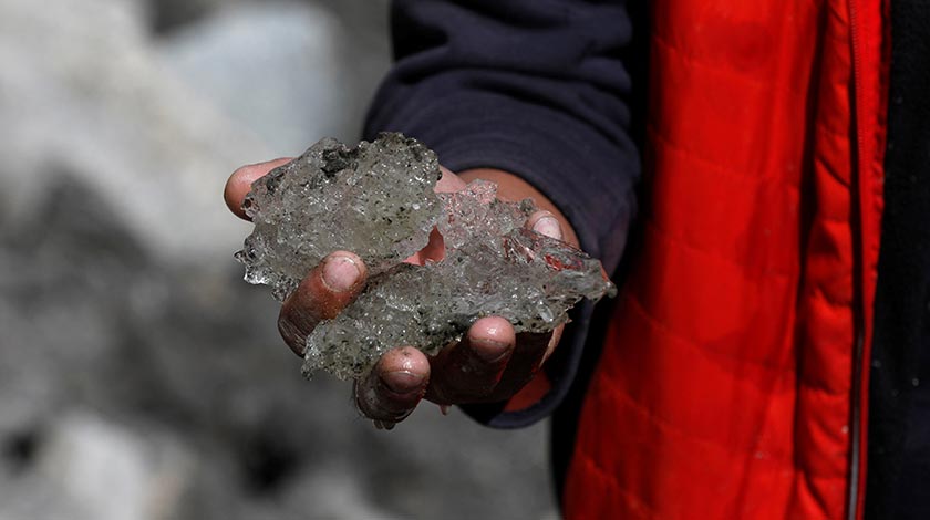Tariq Jamil, 51, chairman of the Community Based Disaster Risk Management Centre, poses with ice taken from the Shisper glacier, near Hassanabad village, Hunza valley, in the Karakoram mountain range in the Gilgit-Baltistan region of Pakistan. - REUTERS