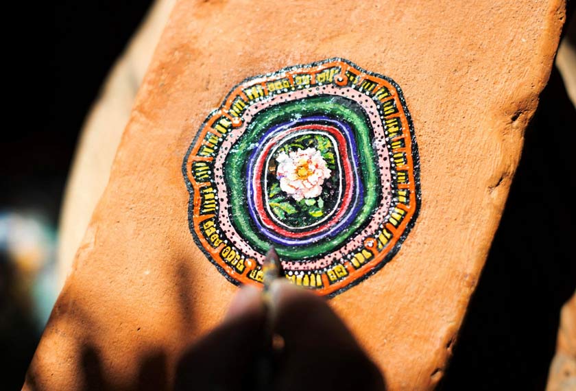 Ben Wilson, shows his painting on a piece of chewing gum, stuck on a brick, in his home studio in Muswell Hill, London, Britain. - REUTERS/Anna Gordon