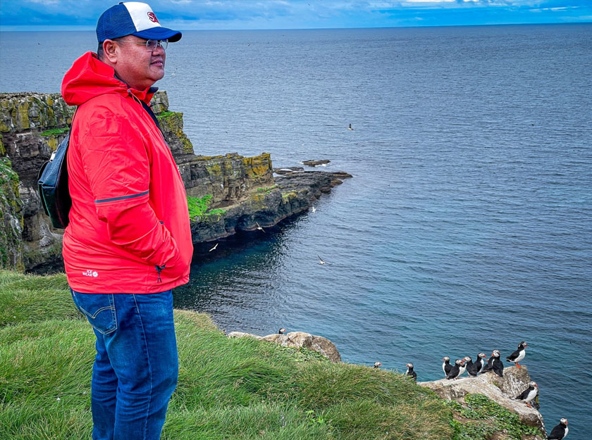 Merakam foto bersama burung puffin yang memenuhi tebing pulau.