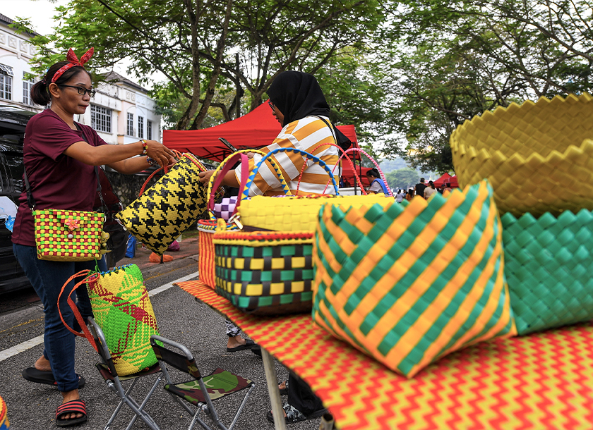Peniaga barangan kraftangan Mazlina Marzuki (kiri) melayan pelanggan yang memilih barangan jualannya di Pasar Tamu Dayak Seremban, Jalan Seri Rahang, baru-baru ini. - Foto Bernama