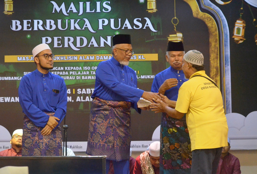 Ahmad Nazri (tengah) menyampaikan sumbangan duit raya kepada gologngan asnaf pada Majlis Berbuka Puasa Perdana di Masjid Al-Mukhlisin, Alam Damai baru-baru ini.