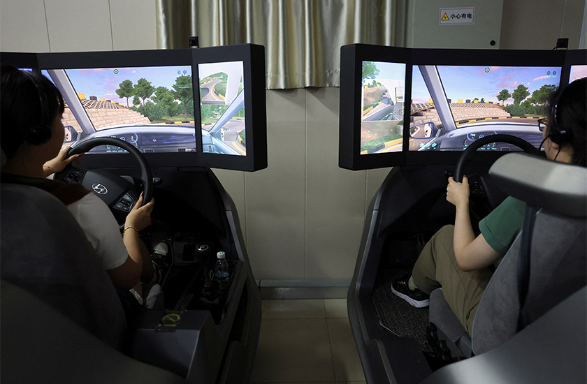 Students wearing virtual reality (VR) headsets practise on car driving simulators at Eastern Pioneer Driving School in Beijing, China. - REUTERS