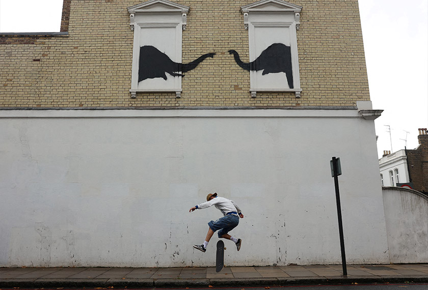 A person skateboards by a new artwork by the British artist Banksy, in Fulham, London, Britain. - REUTERS