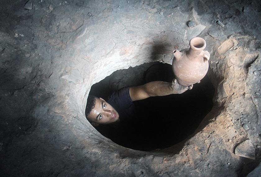 A person lifts a pot as Palestinians work in a pottery workshop to respond to an increase in the demand for clay pots used to cool water due to power cuts and hot weather, according to workers. - REUTERS