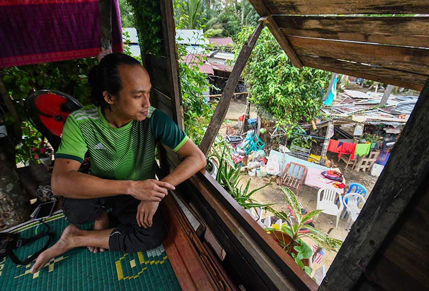 Mohd Nor Afiq meninjau keadaan sekitar rumah dari pondok yang dibina atas pokok di Kampung Kubang Tebakang, Pasir Mas. - Foto BERNAMA