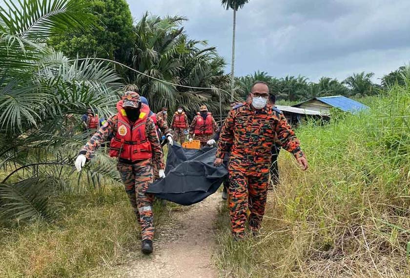 Anggota bomba mengangkat mayat seorang lelaki yang ditemukan terapung dalam sungai di Kampung Parit Mantan, Batu Pahat pada Isnin. - Foto Sinar Harian