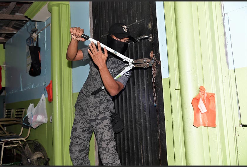 Anggota JIM mengumpil rantai besi untuk membuat pemeriksaan ke atas sebuah rumah ketika operasi yang dijalankan di kawasan ladang kelapa sawit di Setia Alam pagi tadi. --fotoBERNAMA