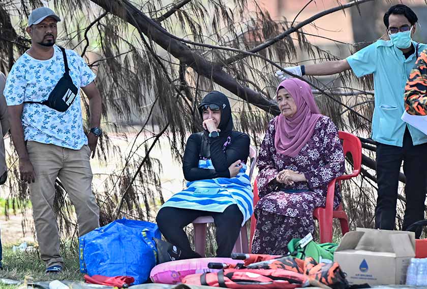 Isteri mangsa, Nora Elina Abdul Khalil, 44, (dua, kiri) tidak dapat menahan kesedihan selepas suaminya Zulkarnain Mohamed Zubir, 44, dikhuatiri lemas selepas dihanyutkan arus di Pantai Batu Buruk hari ini. - Foto Bernama