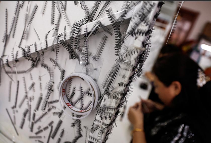 False eyelashes are stuck to a partition on a table at a workshop of Monsheery, in Pingdu, Shandong province, China. - REUTERS