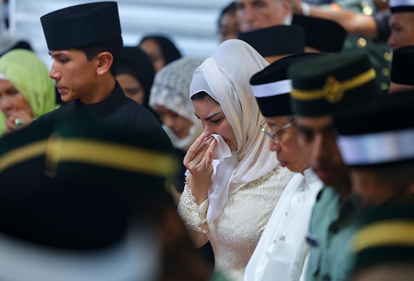 Isteri bekas Yang Dipertua Negeri Sarawak Allahyarham Tun Abdul Taib Mahmud, Toh Puan Ragad Kurdi Taib menahan sebak ketika Istiadat Pengebumian Negeri di Tanah Perkuburan Keluarga di Demak Jaya hari ini. - Foto Bernama