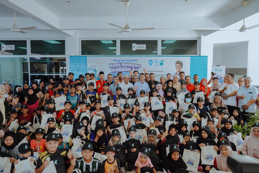 Muhammad Faiz menyantuni 100 pelajar sekolah yang merupakan anak-anak nelayan di bawah seliaan PNK Perlis Selatan dalam 'Program Madani Anak Nelayan Kembali ke Sekolah', semalam. - Foto Facebook Muhammad Faiz