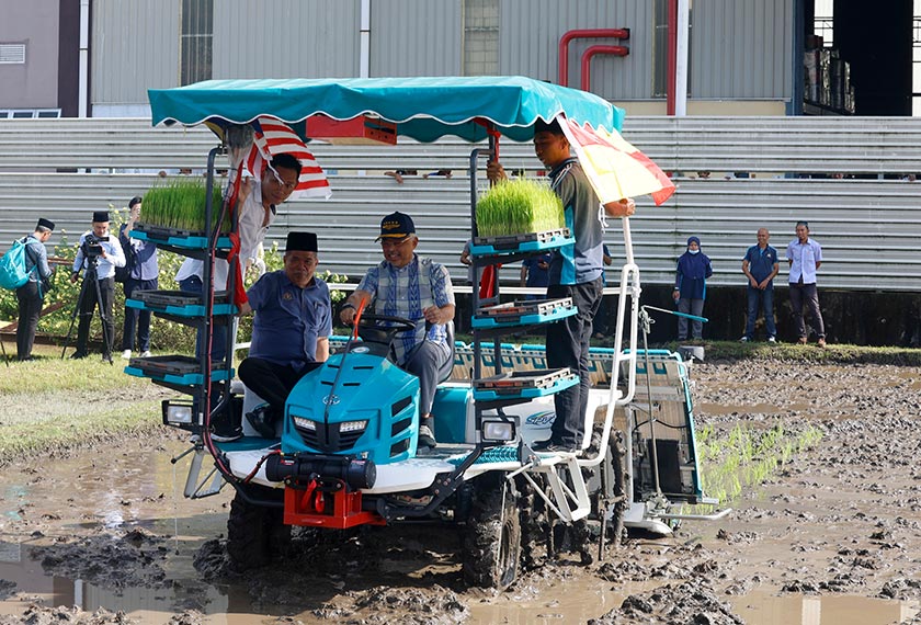 Yang di-Pertuan Agong Al-Sultan Abdullah Ri'ayatuddin Al-Mustafa Billah Shah (tengah) berkenan mencuba mengendalikan jentera menanam benih padi ketika berangkat ke Majlis Menuai Padi di Sekinchan, hari ini. - Foto Bernama
