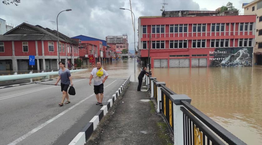Ka Chuan sanggup meredah air sehingga paras dada untuk mengambil kelengkapan anaknya di kedai miliknya. - Foto Astro AWANI