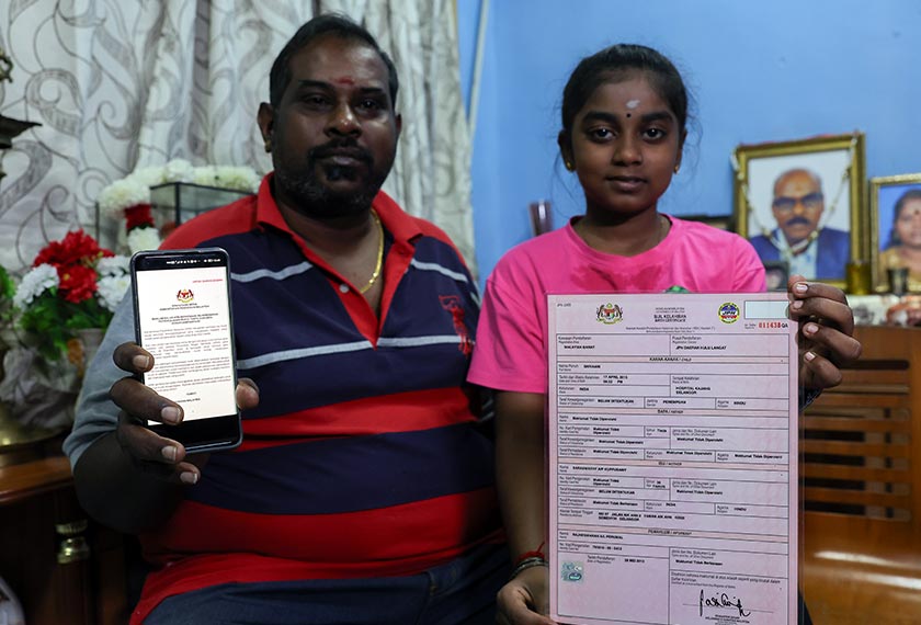 Shivaani bersama bapanya menunjukkan kenyataan media dan surat beranak ketika ditemu bual. --fotoBERNAMA