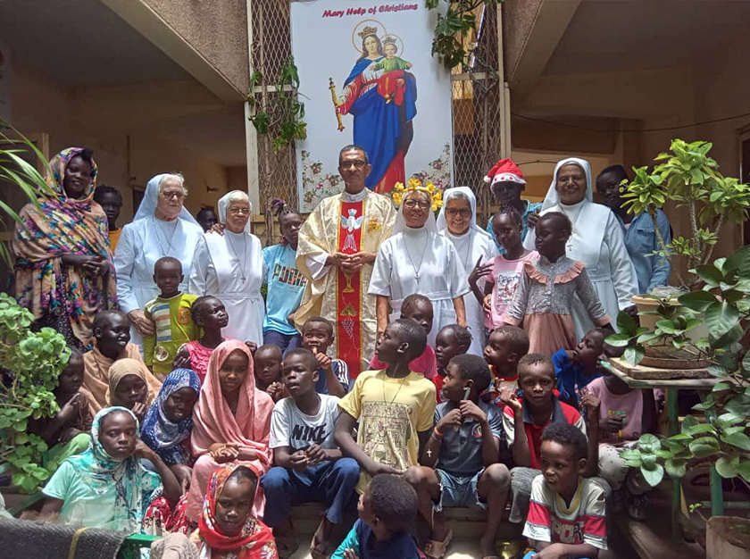 Priest Jacob, nuns and the refugees pose for a photos at 