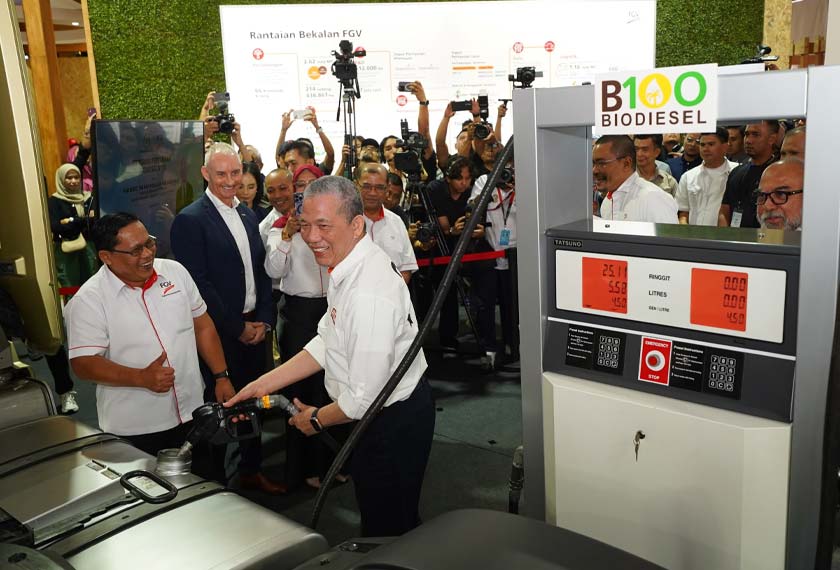 Fadillah Yusof menunjukkan gimik pengisian bahan api boleh baharu iaitu biodesel B100 pada lori tangki FGV. - Gambar FGV