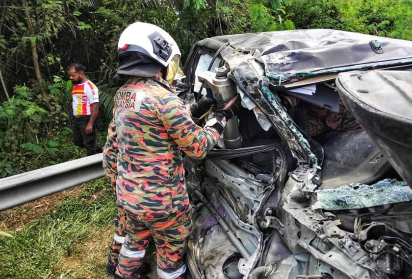 Anggota bomba mengeluarkan mangsa yang tersepit dalam Hilux terbabit. - Foto ihsan JBPM