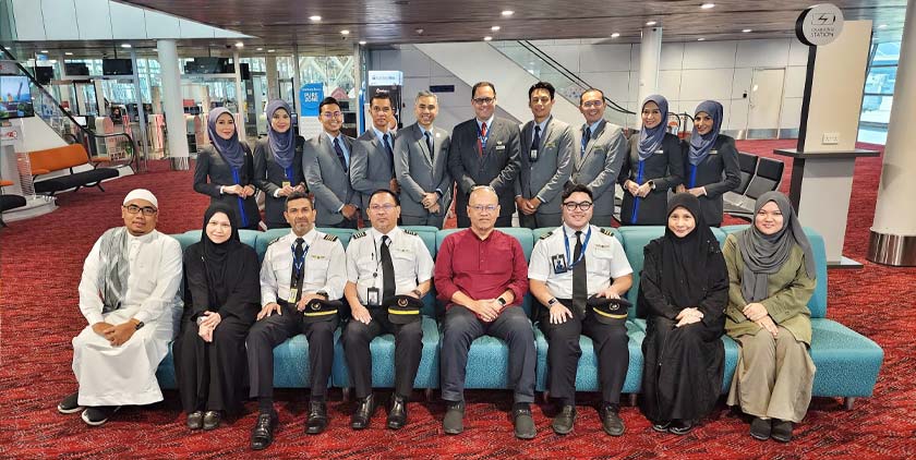 Muhammad Najmi (duduk, empat dari kanan) bergambar bersama barisan juruterbang, anak-anak kapal serta pegawai-pegawai dari Amal dan MAG yang menyertai pakej umrah baru-baru ini. - Gambar Astro AWANI