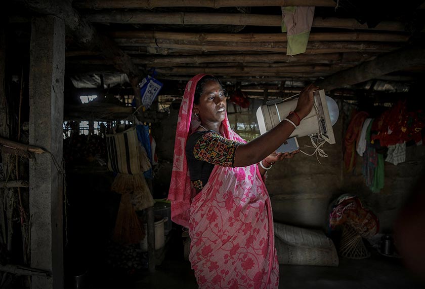 Manimala Sagar, 35, shows a solar light that she uses in her house on Ghoramara Island in the Sundarbans, West Bengal, India. - REUTERS