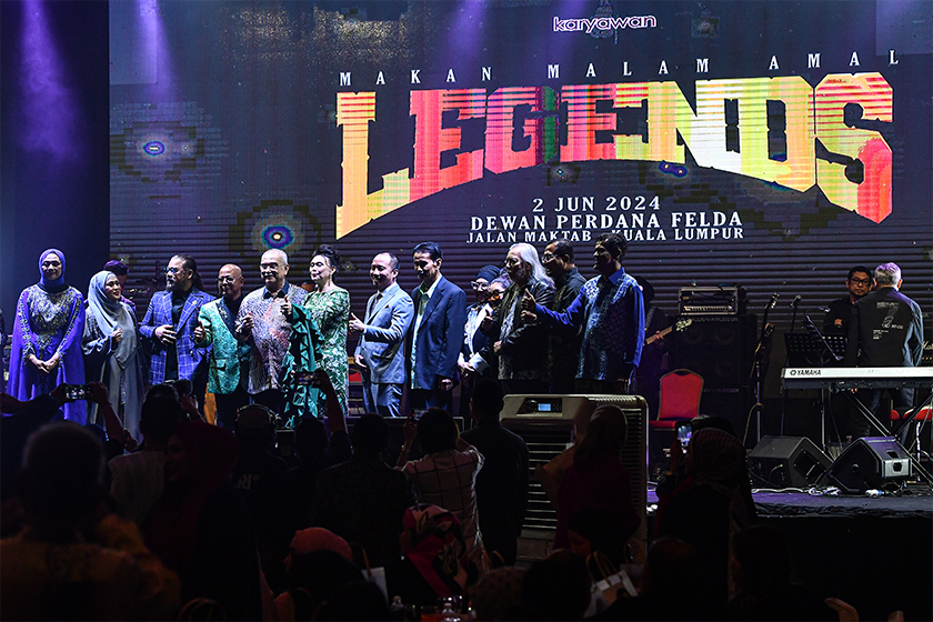 Yang Dipertua Negeri Melaka Tun Mohd Ali Rustam (tengah) bergambar bersama penyanyi-penyanyi veteran pada Konsert Makan Malam Amal “The Legends“ di Dewan Perdana Felda malam tadi. - Foto Bernama
