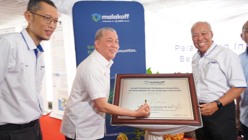 Datuk Seri Fadillah Yusof menandatangani plak perlancaran inisiatif kombinasi pembakaran biojisim di Loji Janakuasa Tanjung Bin Power, disaksikan Pengarah Urusan merangkap Ketua Pegawai Urusan Kumpulan Malakoff, Anwar Syahrin Abdul Ajib (kiri) serta Pengerusi Malakoff, Tan Sri Dr. Ir. Ahmad Tajuddin Ali.