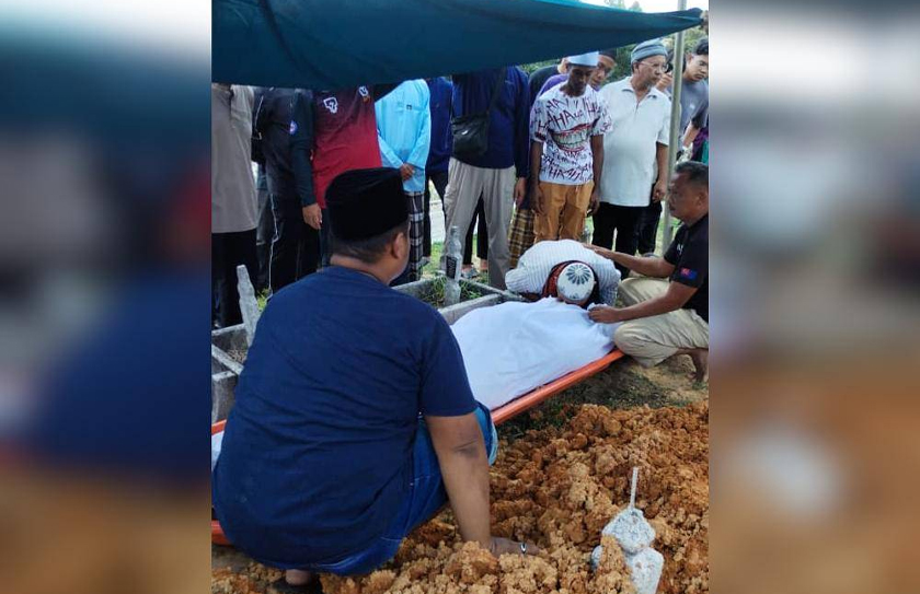 Ahmad Shahfarin mengucup anaknya sebelum dikebumikan, pada Jumaat. - Foto Sinar Harian