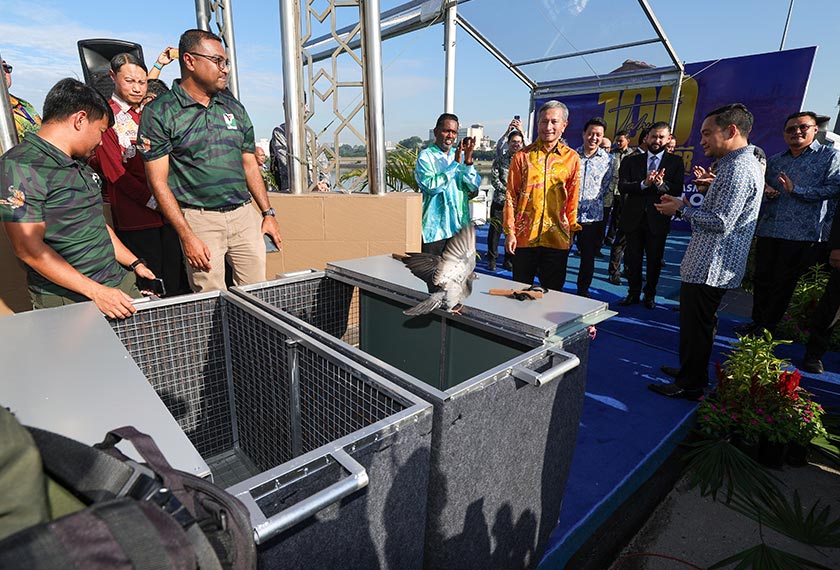 Tunku Mahkota Ismail bersama Onn Hafiz dan Vivian menyaksikan pelepasan burung merpati sebagai simbolik Sambutan 100 Tahun Tambak Johor di tengah tambak sempadan Johor dan Singapura hari ini. --fotoBERNAMA