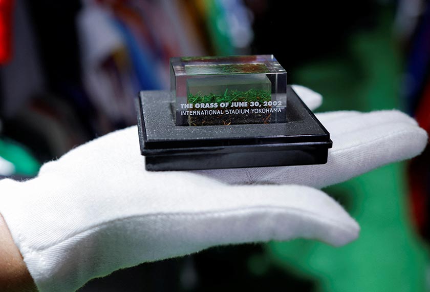 Cassio Brandao holds the grass of the International Stadium Yokohama inside a glass box, in Sao Paulo, Brazil. - REUTERS 
