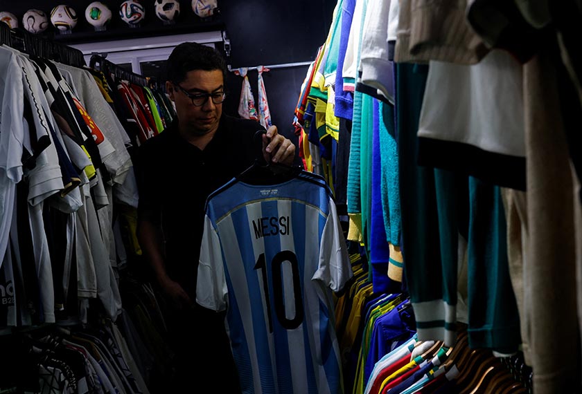 Cassio Brandao holds an Argentina jersey of Lionel Messi  in Sao Paulo, Brazil. - REUTERS