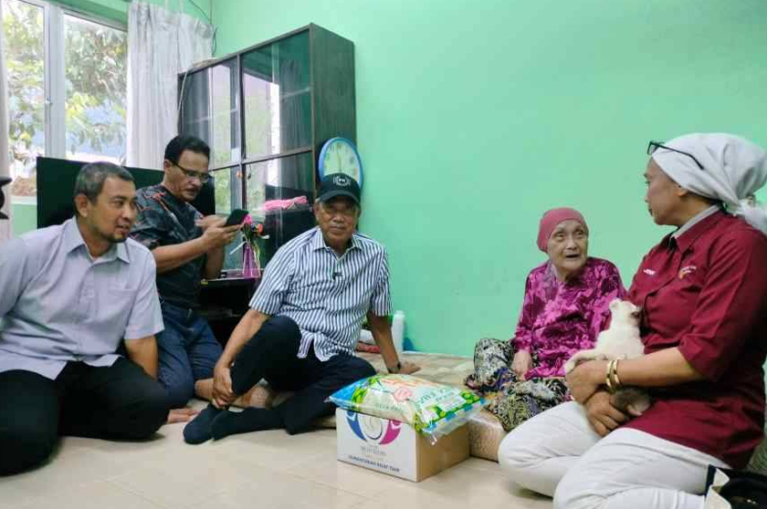 Muhyiddin (dua dari kiri) menyantuni warga emas, Jemah Kassim, 91 pada program Ziarah Kasih Ramadan di Pekan Pagoh pada Ahad. - Foto Sinar Harian