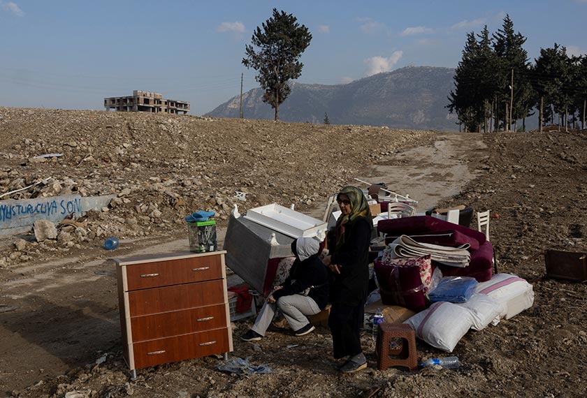 Hatice Altinoz and her daughter are seen beside their belongings, as they wait for a truck to load them, after they received a text message telling them that the government is transferring their property to the Treasury under a new urban transformation law, in Hatay, Turkey. - REUTERS
