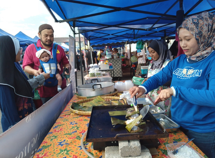Nani (kanan) menjual kuih tradisional di Bazar Ramadan Kepala Batas.